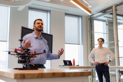 Dr. Walid Saad and a Alexander DeRieux give a demonstration with a drone in the foreground
