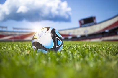 Soccer ball in grass inside stadium