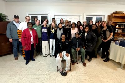 A large group of students and community members pose for a photo.