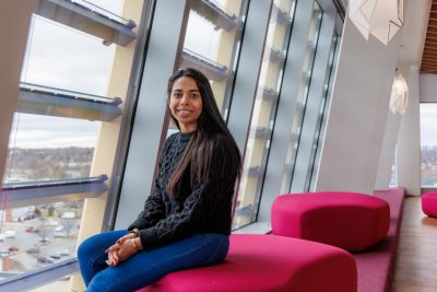 Niharika Adhikari sitting by a window in the new Academic Building One in Alexandria