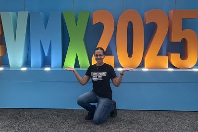Melani French in front of the VMX 2025 sign.