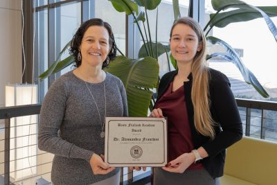 Natalia Henao-Guerrero (at left) presenting the Bente Flatland Resident Award to Alessandra Franchini (at right) at the Veterinary Teaching Hospital. 