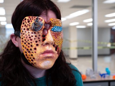 Sarah Fasco, creative technologies ‘22, models her 3D-printed mask that’s design is based off of trypophobia, the fear of holes. Photo by Chase Parker for Virginia Tech.