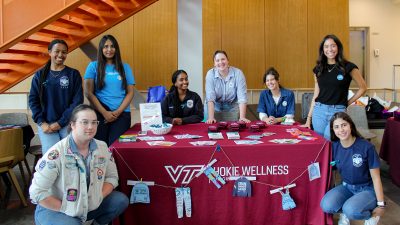 Volunteers, all wearing denim jeans, gather around a table.