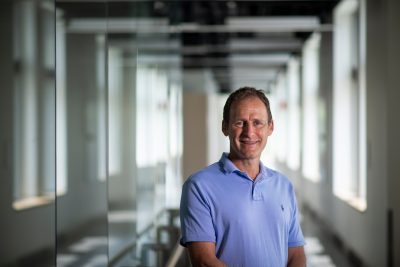 William Ducker stands in hallway of academic building
